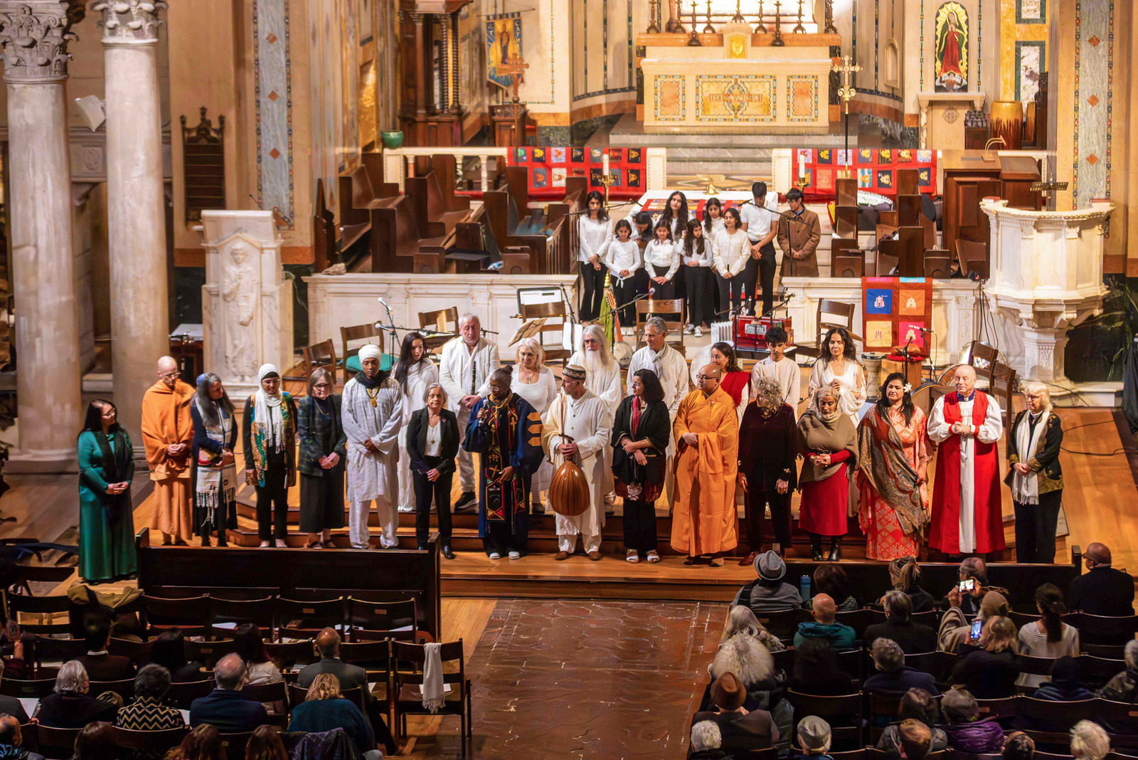Group of people on stage of diverse backgrounds and faiths