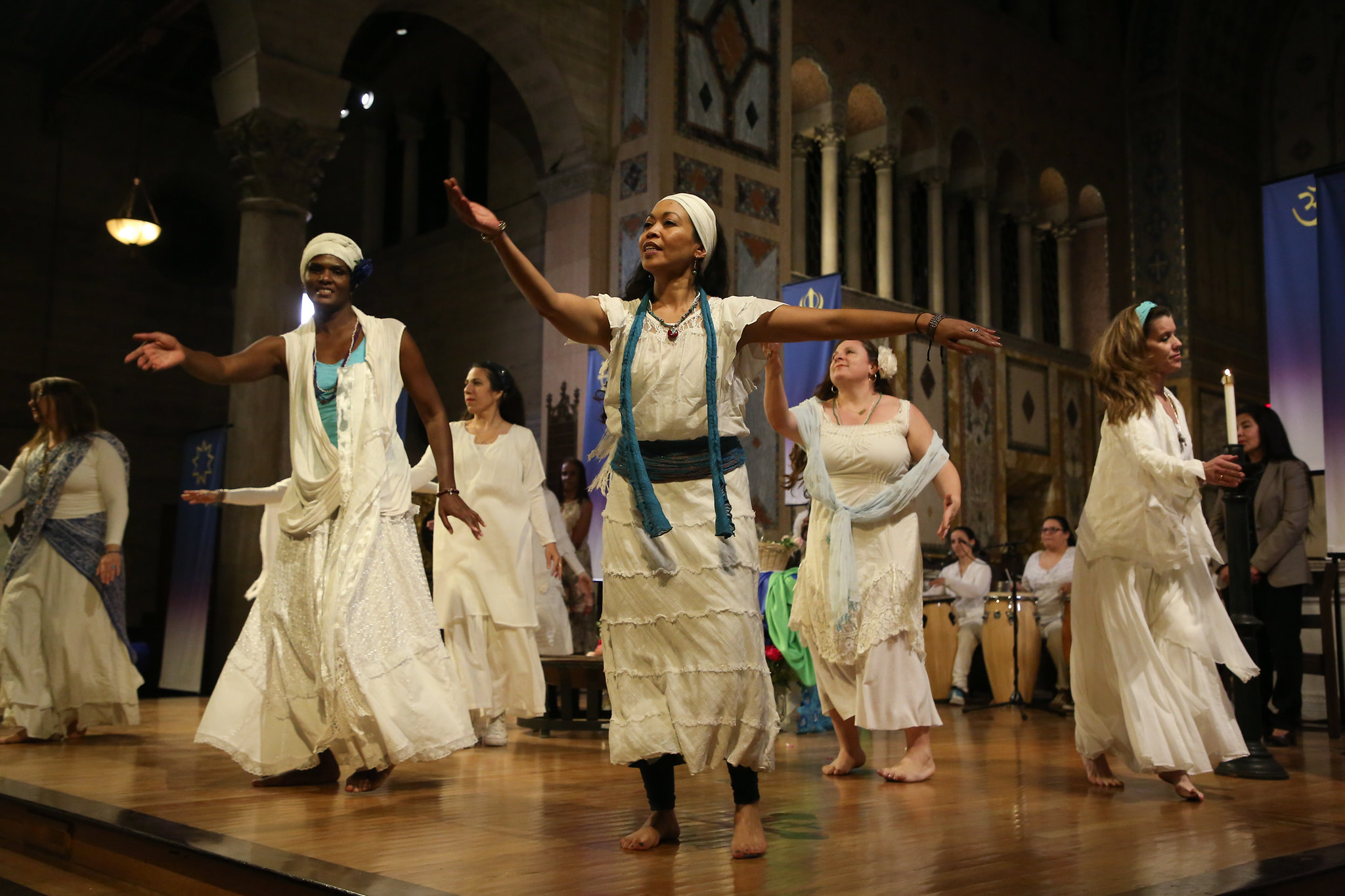 Group on the stage dancing with white dresses